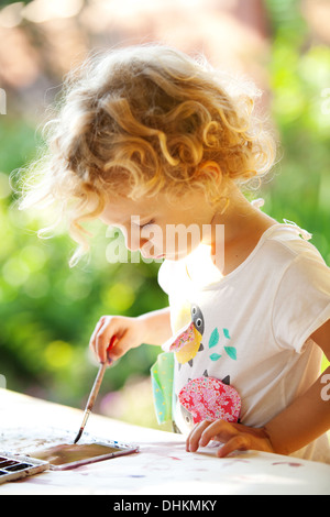 Portrait of little girl painting, summer outdoor Stock Photo