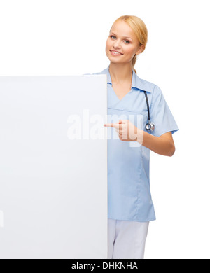 smiling female doctor or nurse with blank board Stock Photo
