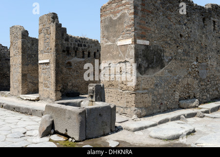 Fountain with a relief of a head of a bull along street Via della Fortuna, Pompeii Italy. Stock Photo