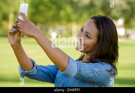 Outdoor portrait of a beautiful African American taking a photo with the cellphone Stock Photo