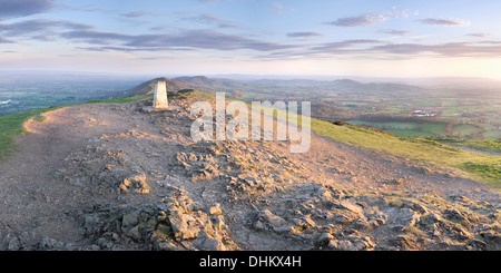 The Summit Trig point on the Worcestershire Beacon overlooks the entire Malvern Hills at sunset. Stock Photo