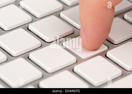 Close-up index finger is pressing an empty computer keyboard key with bokeh effect Stock Photo