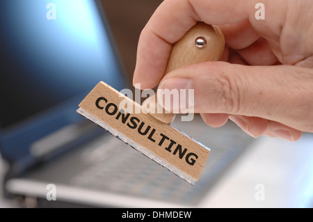 rubber stamp in hand marked with consulting Stock Photo