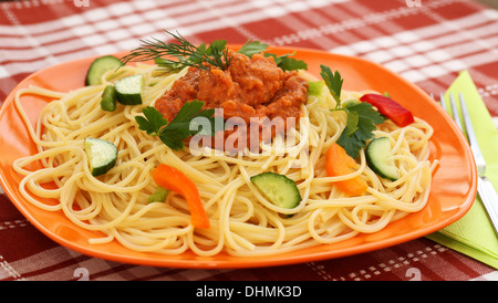 Spaghetti pasta with sauce and vegetables on table. Stock Photo