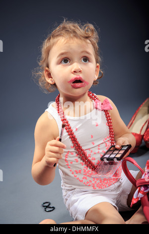 studio shot of a little girl making oneself up Stock Photo