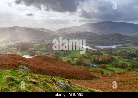 View from the top of Loughrigg Fell, looking across to Loughrigg Tarn, Elterwater and the Langdale Valley. Stock Photo