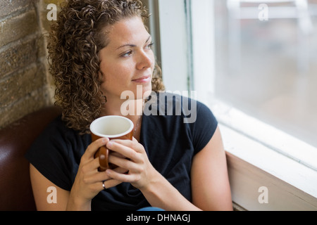 Thoughtful Woman With Coffee Mug In Cafe Stock Photo