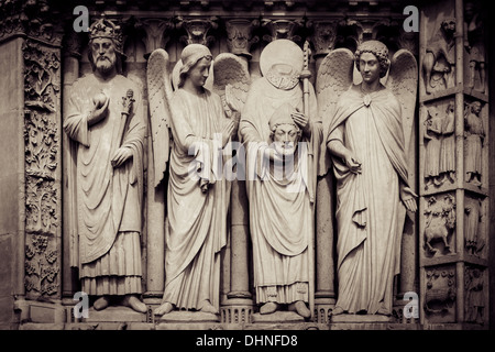 Saint Denis -holding his own head, statue on the front facade of Cathedral Notre Dame, Paris France Stock Photo