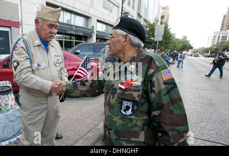 Vietnam war male Hispanic veteran, greets, shakes hands with crowd, children during a Veteran's Day parade Stock Photo