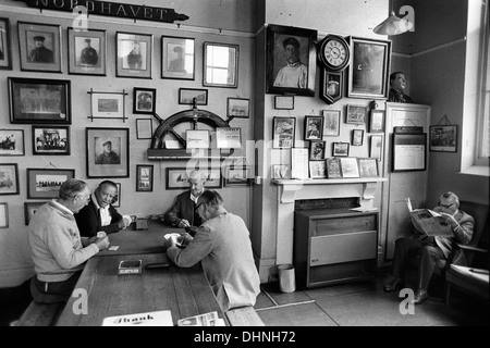 Southwold Sailors Reading Room Museum Suffolk. Interior of local museum dedicated to the sailing tradition in Southwold and East Anglia. Local men playing cards and one reading a newspaper. England 1984 1980s UK HOMER SYKES Stock Photo