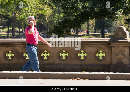 Senior Man Talking on Cell Phone while Walking in Central Park, NYC Stock Photo