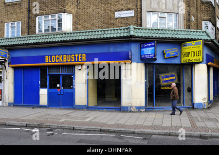 A man walks past a closed down Blockbuster shop in South London, UK Stock Photo