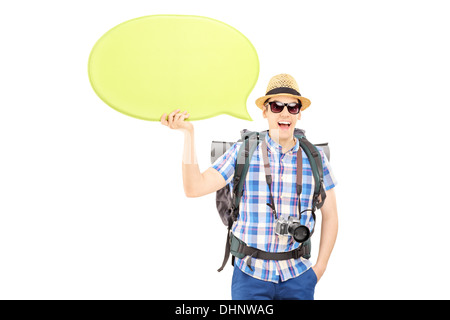 Young smiling tourist holding an empty speech bubble and looking at camera Stock Photo