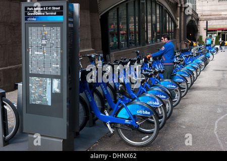 A man checks out a bike from a Citi Bike NYC bike sharing program docking station in Pershing Square in New York City. Stock Photo