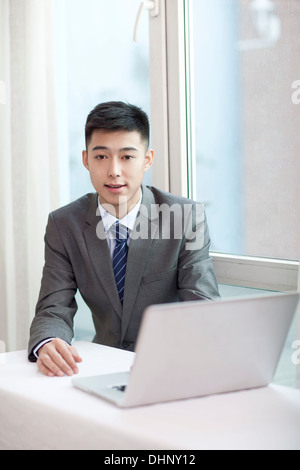 Businessman sitting by a laptop Stock Photo