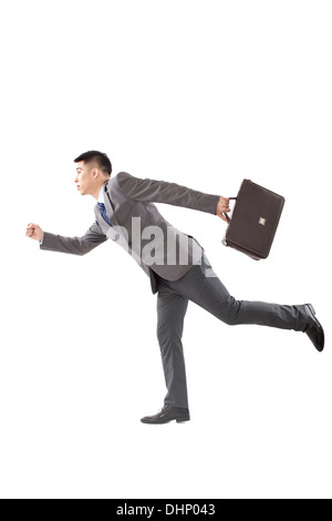 Young businessman holding briefcase and running Stock Photo