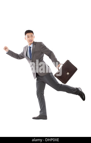 Young businessman holding briefcase and running Stock Photo