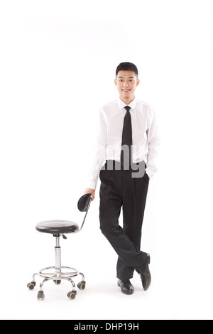 Businessman standing near a swivel chair Stock Photo