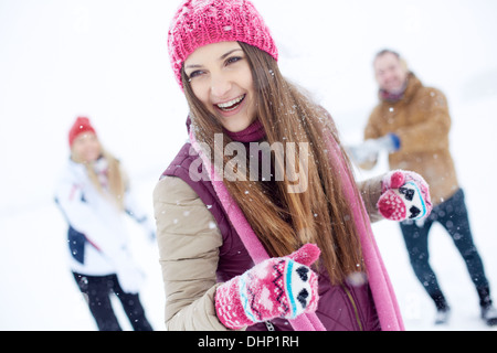 Portrait of happy girl in winterwear laughing while playing with her friends outside Stock Photo