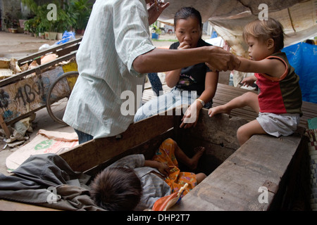 A 5-year-old boy living in poverty & afflicted with Down syndrome (DS) gets into a garbage cart in Kampong Cham, Cambodia. Stock Photo