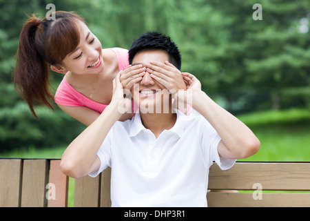 Young woman covering man's eyes Stock Photo