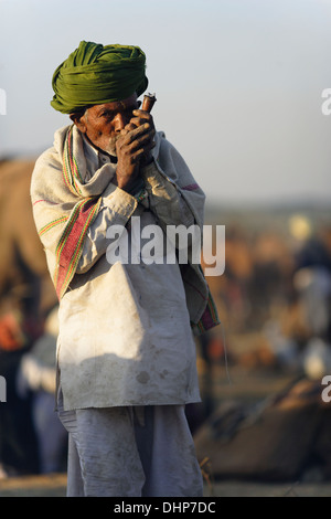 Indian Man Smoking Handmade Chillum Pipe at Pushkar camel Fair, India. Stock Photo