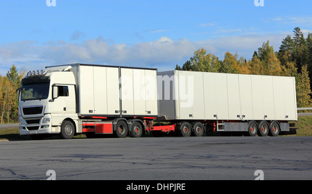 New and big white semi trailer truck on a parking lot in autumn. Stock Photo