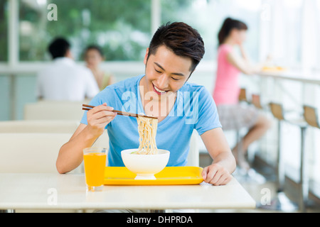 Young man having a meal in restaurant Stock Photo