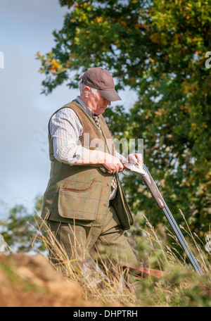 A man loading a shotgun stood  waiting for the start of a pheasant shoot in England Stock Photo