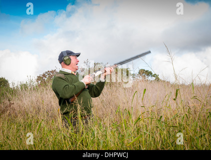 A man with a shotgun stood  waiting for the start of a pheasant shoot in England Stock Photo
