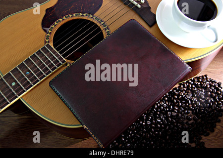 The Concepts that White coffee cup and old note paper resting on guitar. Stock Photo