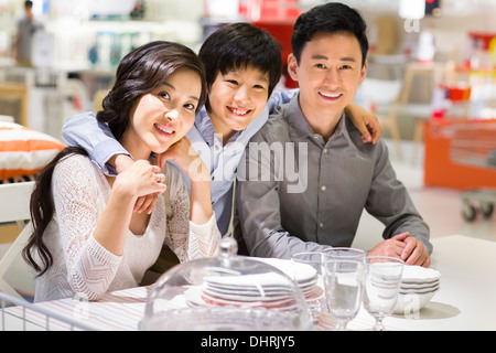 Cheerful family sitting side by side and smiling Stock Photo