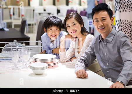 Cheerful family sitting side by side and smiling Stock Photo