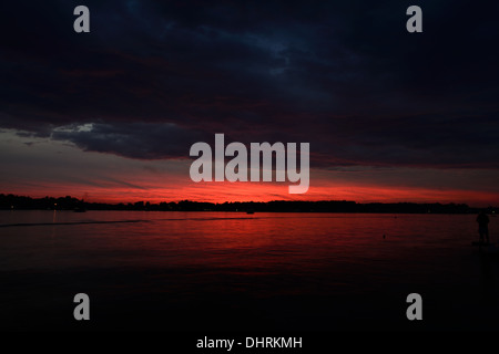 Evening fiery red sunset colors and clouds over Lake James in Angola, Indiana USA. Stock Photo