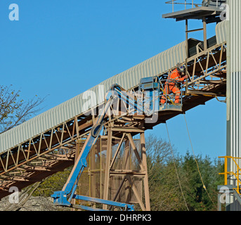 Man working on conveyor. Shap Beck Quarry, Shap, Cumbria, England, United Kingdom, Europe. Stock Photo