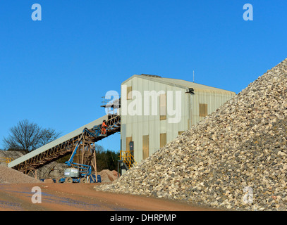 Man working on conveyor. Shap Beck Quarry, Shap, Cumbria, England, United Kingdom, Europe. Stock Photo