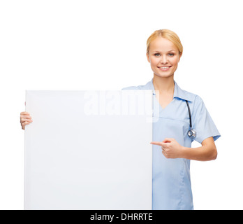 smiling female doctor or nurse with blank board Stock Photo