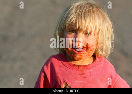 Smeared face of a little blond boy child chocolate face Stock Photo