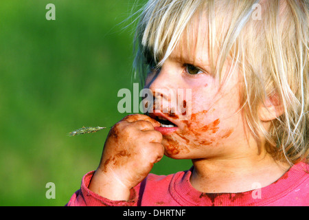 A smeared chocolate face, a little blond boy child face Stock Photo