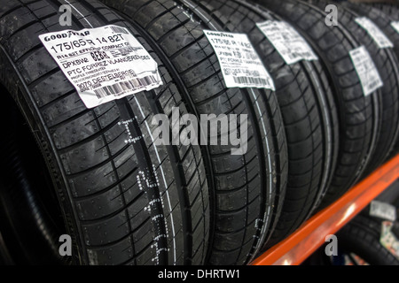 Close up of row of new Goodyear summer tires for cars stored on shelf in workshop of tire center Stock Photo