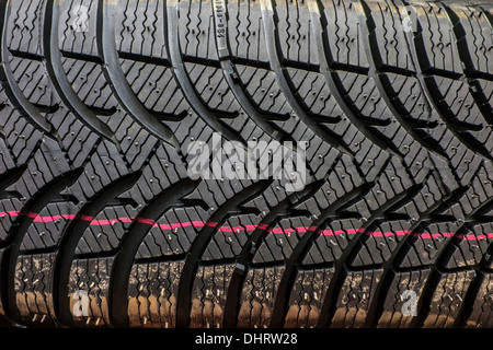 Close up of new winter tire / snow tyre for car showing rubber tread profile with deep grooves and additional sipes Stock Photo