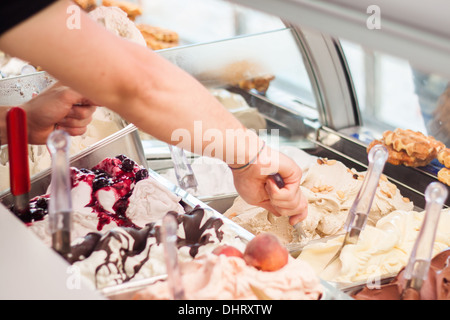 selling 'person hand' hand gelato ice-cream showcase  gelateria  'ice cream' closeup 'chocolate syrup' dolce 'berries ice cream' Stock Photo