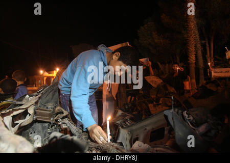 Nov. 14, 2013 - Rafah, Gaza Strip, Palestinian Territory - Palestinian children put candles on the remains of the car that late Hamas military commander Ahmed al-Jaabari was riding in when he was killed in an Israeli air strike, during the first anniversary of his death, at Rafah Crossing in the southern Gaza Strip, November 14, 2013. al-Jaabari was killed by an Israeli military strike while driving along Omar Mukhtar Street in Gaza City in the attack, which was a joint operation by the Shin Bet and the IDF, came amid a series of Palestinian rocket attacks against Israel and Israeli air strike Stock Photo