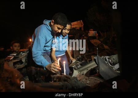 Nov. 14, 2013 - Rafah, Gaza Strip, Palestinian Territory - Palestinian children put candles on the remains of the car that late Hamas military commander Ahmed al-Jaabari was riding in when he was killed in an Israeli air strike, during the first anniversary of his death, at Rafah Crossing in the southern Gaza Strip, November 14, 2013. al-Jaabari was killed by an Israeli military strike while driving along Omar Mukhtar Street in Gaza City in the attack, which was a joint operation by the Shin Bet and the IDF, came amid a series of Palestinian rocket attacks against Israel and Israeli air strike Stock Photo