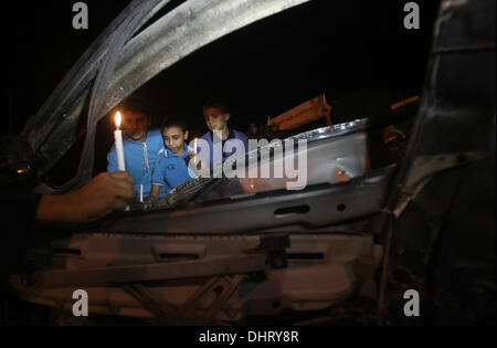 Nov. 14, 2013 - Rafah, Gaza Strip, Palestinian Territory - Palestinian children put candles on the remains of the car that late Hamas military commander Ahmed al-Jaabari was riding in when he was killed in an Israeli air strike, during the first anniversary of his death, at Rafah Crossing in the southern Gaza Strip, November 14, 2013. al-Jaabari was killed by an Israeli military strike while driving along Omar Mukhtar Street in Gaza City in the attack, which was a joint operation by the Shin Bet and the IDF, came amid a series of Palestinian rocket attacks against Israel and Israeli air strike Stock Photo