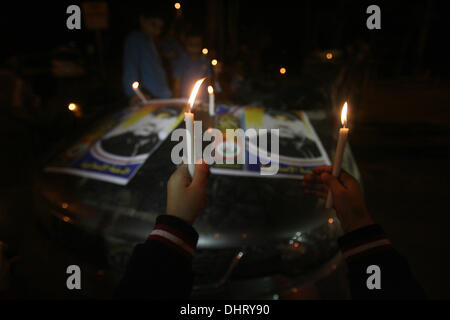 Nov. 14, 2013 - Rafah, Gaza Strip, Palestinian Territory - Palestinian children put candles on the remains of the car that late Hamas military commander Ahmed al-Jaabari was riding in when he was killed in an Israeli air strike, during the first anniversary of his death, at Rafah Crossing in the southern Gaza Strip, November 14, 2013. al-Jaabari was killed by an Israeli military strike while driving along Omar Mukhtar Street in Gaza City in the attack, which was a joint operation by the Shin Bet and the IDF, came amid a series of Palestinian rocket attacks against Israel and Israeli air strike Stock Photo