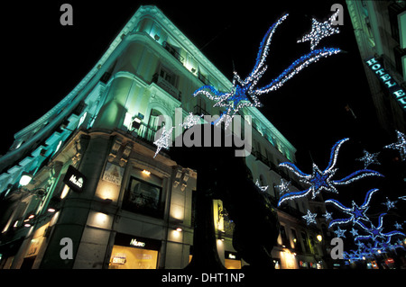 Christmas Lights in Calle del Carmen with the 'Oso y el madroño' most famous symbol of Madrid: a 20 ton statue of a bear eating. Puerta del Sol, Madri Stock Photo