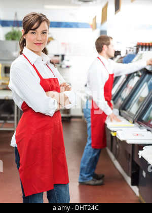 Female Butcher Standing Arms Crossed At Store Stock Photo