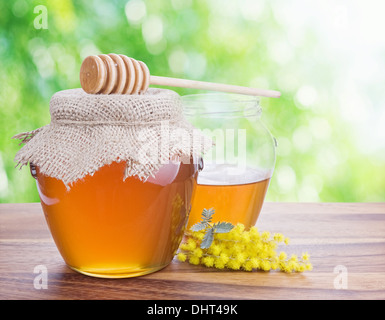 Honey in glass jars against nature bokeh background. Stock Photo