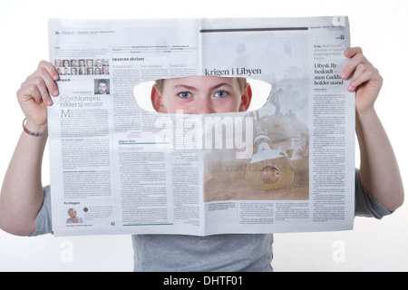 Boy looking through a newspaper hole as a spy Stock Photo